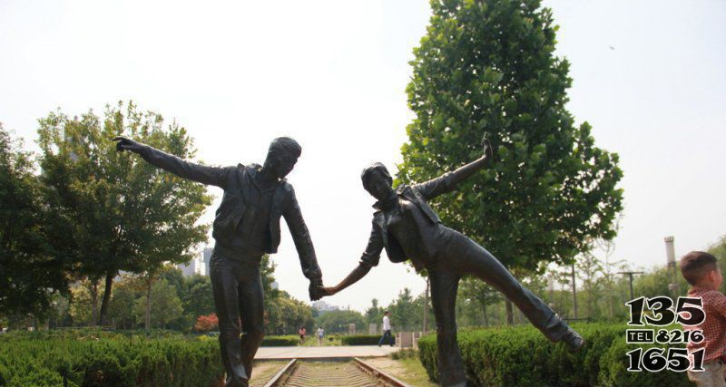 公园走火车道的情侣小品铜雕图片
